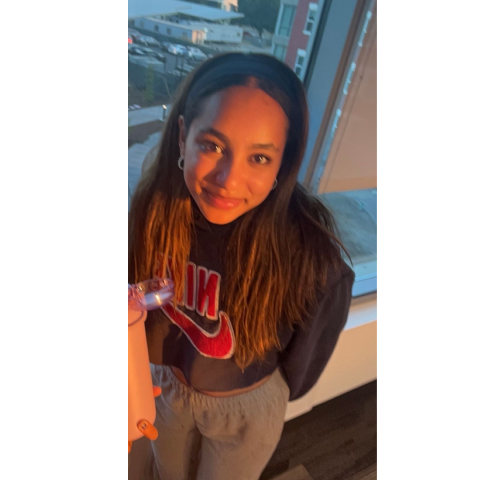 Portrait of Student Health Peer, Christiani Marte, in front of a window at the JC campus.